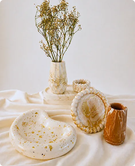 Vase avec fleurs séchées, coupelles marbrées et vide-poches en jesmonite aux tons blanc, doré et terracotta